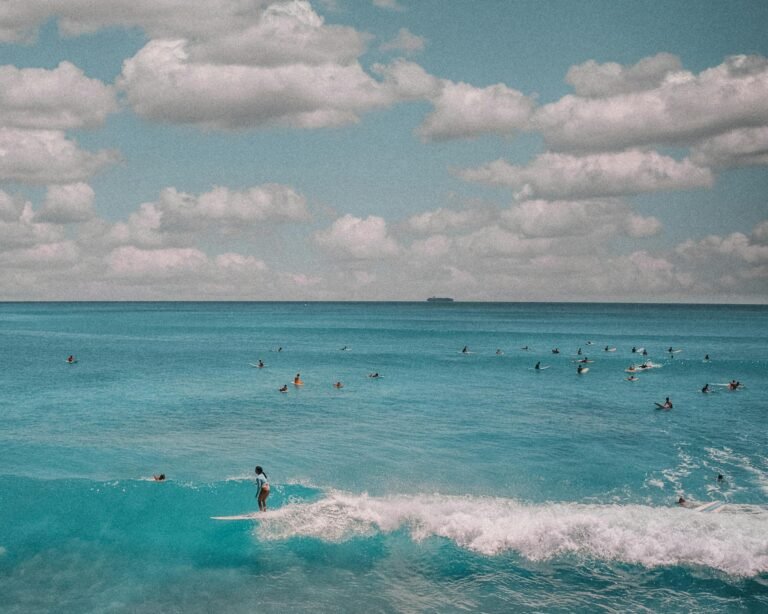 A captivating view of surfers riding waves at Waikiki Beach in Honolulu with a vibrant blue ocean.